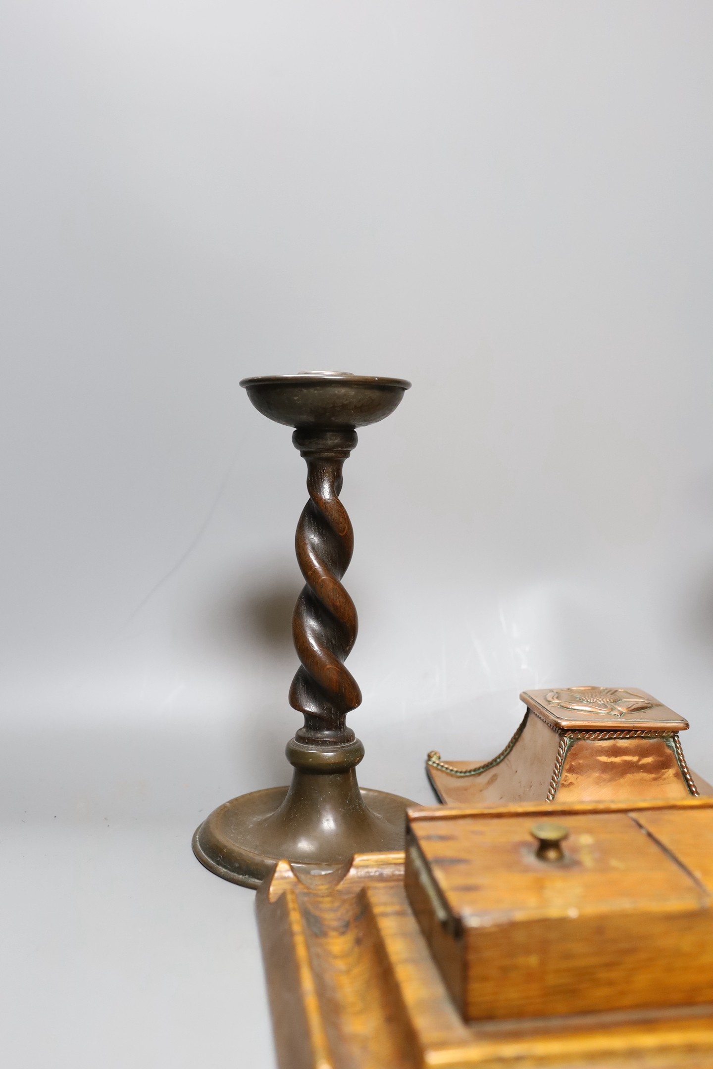 A copper Arts & Crafts inkwell, a pair of A Jones turned candlesticks and an early 20th century oak ink stand (4)